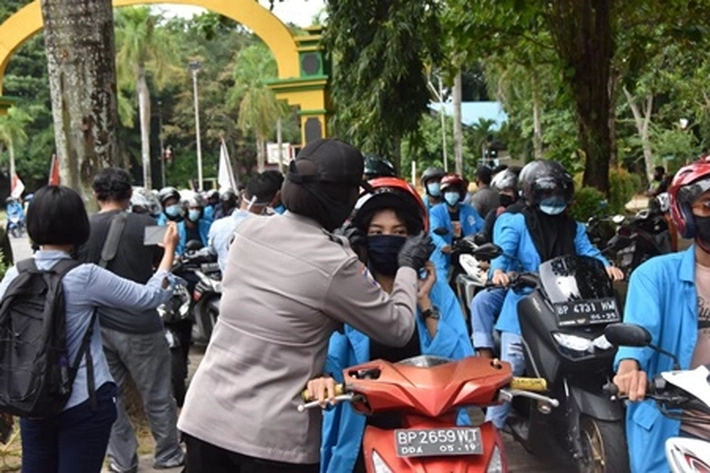 Ditengah Pengunjuk Rasa, Polwan Bagikan Masker