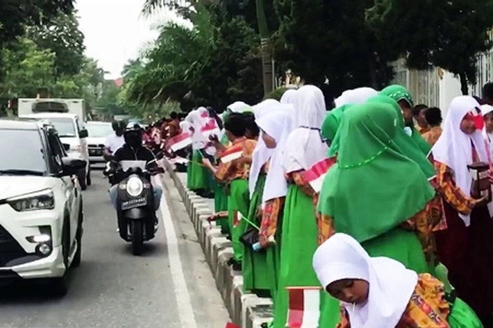 Ribuan Siswa Sambut Kedatangan Presiden Jokowi dengan Membawa Bendera Merah Putih